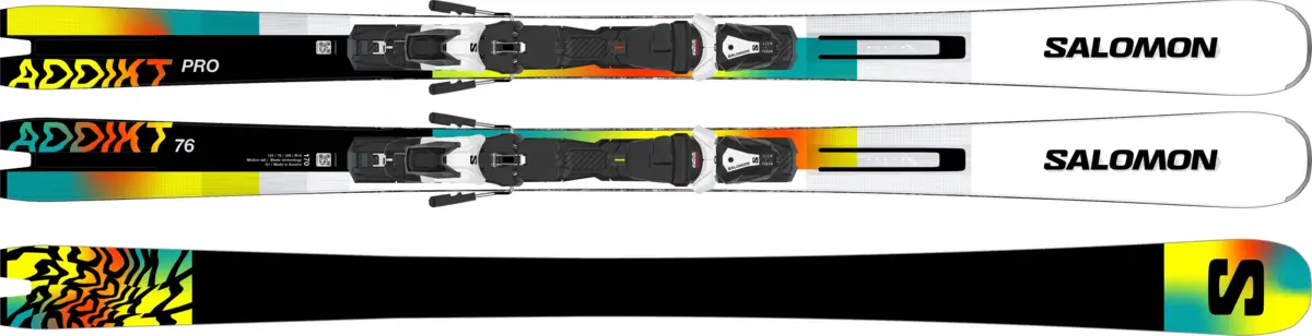 Deux paires de skis Salomon Addikt colorés (jaune, orange, turquoise, noir) avec fixations et une base de ski noire à motifs abstraits.